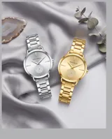 Reloj de pulsera analógico Mini Focus con caja y malla de acero inoxidable en color plateado. Presenta una esfera minimalista con un detalle circular texturizado en el centro y cierre de seguridad plegable con botón de liberación.