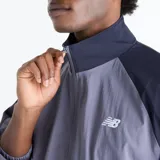 Campera deportiva New Balance Sport Legacy en tonos gris y azul marino, con diseño de bloques de color, cuello alto, cierre frontal completo y el logotipo Flying NB bordado en el pecho.