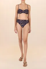 Calzón de bikini amplio azul oscuro con estampado de cadenas y cuerdas doradas. Presenta una faja que define la silueta, recogidos laterales y corte a la cadera.