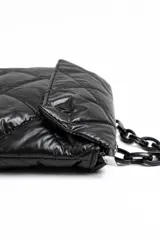 Cartera acolchada negra de material sintético con efecto brillante y costuras en rombos. Cuenta con solapa frontal y una correa corta de cadena gruesa de eslabones plásticos negros.
