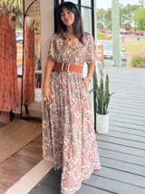 Vestido largo de corte amplio con estampado floral en tonos turquesa, blanco y rosa. Posee escote en V, mangas cortas y espalda con lazo.