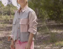 Chaqueta color beige con estampado abstracto en tonos amarillos, con cuello camisero, cierre frontal con botones, bolsillos plaqué y puños camiseros.