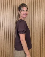 Blusa blanca de corte recto con escote a la base y mangas cortas abullonadas con terminación fruncida.