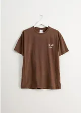 Remera marrón de corte oversized con estampa en la espalda.