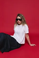 Remera de algodón color blanco con diseño de tablas verticales en el frente que aportan movimiento y estructura.