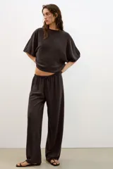 Top blanco de tejido rústico, con cuello redondo y mangas cortas amplias. Bajo recto.