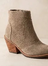 Bota corta de cuero vacuno en color azul oscuro, con diseño de caña media, punta almendrada y taco cuadrado de 7 cm. Presenta costuras decorativas laterales y suela de caucho antideslizante.