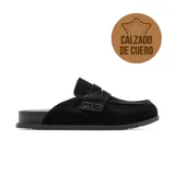 Zuecos de cuero color negro, estilo mocasín destalonado, con costuras visibles y suela plana.