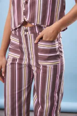 Pantalón de tiro alto con corte recto y estampado de rayas verticales en tonos marrón, rosa pálido y amarillo pálido. Presenta bolsillos delanteros con solapa.