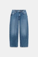 Jeans de tiro medio con diseño baggy balloon, cinco bolsillos y costuras torcidas. Cierre frontal con cremallera y botón metálico.