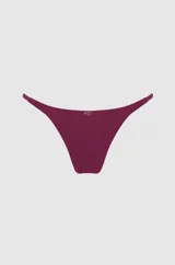 Bombacha de bikini color magenta, de corte vedetina con tiras finas ajustables en los laterales.