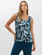Conjunto de tres piezas compuesto por una musculosa de escote redondo, un saco largo abierto de mangas 3/4 y un pantalón palazzo de pierna ancha. La musculosa y el saco presentan un estampado abstracto de pinceladas en tonos azules con hilos metalizados, mientras que el pantalón es de color azul petróleo liso.