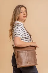 Bandolera mediana de cuero sintético color negro, con correa regulable, bolsillo frontal con cierre y compartimento principal.