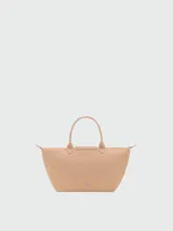 Bolso de mano tipo tote de la línea Le Pliage One de Longchamp, en color beige, con diseño minimalista y estructura flexible.
