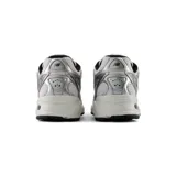 Championes New Balance modelo 509, de color plateado y blanco con detalles en negro, diseño de inspiración retro con capellada de malla transpirable, suela con tecnología ABZORB y cierre de cordones.