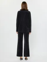 Blazer negro de pana con cuello de solapa, cierre frontal de un botón y bolsillos delanteros.