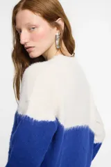 Sweater tejido en jersey con diseño en dos colores: blanco en la parte superior y azul en la parte inferior.