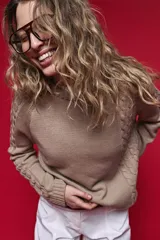 Sweater de tejido de punto negro con tramas de ochos en las mangas y laterales, cuello redondo a la base y mangas largas.