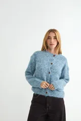 Cardigan de punto texturizado en tono azul jaspeado, con cuello redondo, cierre frontal de botones y mangas largas con puños acanalados.