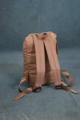 Mochila matera de diseño vertical, color gris azulado, con acabado acolchado y cierres frontales. Cuenta con un compartimento principal espacioso, un bolsillo frontal externo y un asa superior para transporte manual.