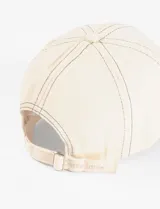 Gorra de gabardina color crudo con pespuntes en contraste y moño bordado en el frente.