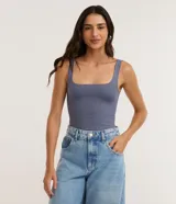 Body sin mangas color azul, con escote cuadrado y breteles anchos. Confeccionado en poliamida con toque suave y caída ajustada. Posee cierre inferior con botones a presión y forro interno.