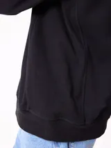 Buzo de cuello redondo Rusty, confeccionado en tejido de algodón y poliéster, con diseño liso en color beige, puños y ruedo acanalados, y detalle de etiqueta de la marca en el frente.