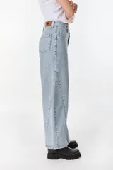 Jean de corte wide leg, color celeste claro, con diseño de costuras decorativas frontales y botamangas amplias.