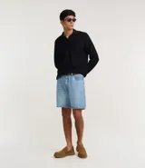 Bermuda masculina de jeans, color celeste claro lavado, de corte recto, con cierre tradicional y bolsillos.