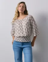 Blusa de microtul estampado con hojas color marrón sobre fondo blanco, marca Harper. Tiene mangas 3/4 amplias y ruedo con punto smock. Incluye forro interno a tono.