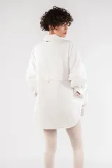 Camisa acolchada marrón con cuello clásico, cierre frontal con botones, manga larga raglán, puños abotonados, bolsillo utilitario en el pecho, bolsillos laterales y canesú abotonado en la espalda.