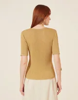 Blusa de tejido de punto metalizado en color dorado, con cuello redondo, mangas cortas y detalles de terminación en crochet en el cuello y los puños. Silueta ajustada.