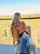 Camisa de lino metalizado color cobre, con cuello camisero, mangas largas abullonadas y corte holgado.