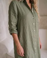 Vestido camisero de lino color marrón, de corte recto y largo midi, con mangas largas abotonadas, cuello camisero y cierre frontal con botones de nácar.