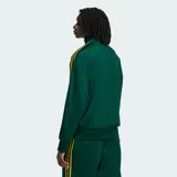 Campera deportiva Adidas Firebird de color verde oscuro con textura de rayas de tiza y detalles en amarillo, incluyendo las clásicas tres tiras en las mangas y el logo del trifolio bordado en el pecho. Cuenta con cuello alto, cierre frontal completo y bolsillos laterales.