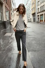 Jeans tobilleros de tiro alto, color negro lavado, con pernera recta y acabado sin costura en el ruedo. Modelo de cinco bolsillos con cierre frontal de cremallera y botón.