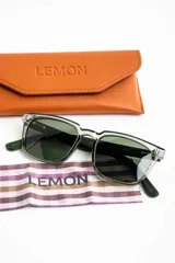 Lentes de sol polarizados con armazón transparente y patillas de madera, con cristales oscuros.