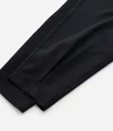 Pantalón de sastrería corte carrot, color negro, con cintura alta, pliegues delanteros, bolsillos laterales y elástico en la parte posterior de la cintura.