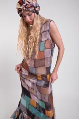 Vestido largo sin mangas de tela calada con estampado estilo patchwork multicolor, cuello alto y volados en el ruedo.