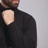 Polera color beige de tejido de punto con cuello alto.