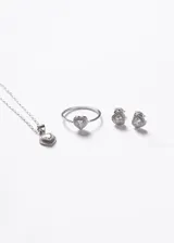 Par de caravanas en forma de corazón, confeccionadas en plata 925 hipoalergénica. Presentan una zirconia central de corte corazón rodeada por un pavé de zirconias blancas más pequeñas.
