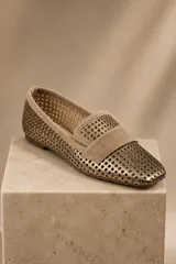 Mocasines chatos de cuero vacuno en color celeste, con diseño calado en toda la superficie y detalle de tira lisa en el empeine. Poseen suela plana y taco bajo de goma.