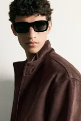 Cazadora bomber de corte regular fit en tejido efecto ante de color marrón oscuro, con cuello alto, cierre frontal de cremallera y bolsillos laterales de vivo.