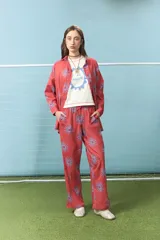 Pantalón de algodón color rojo con estampado de soles en color azul, de corte recto y cintura elástica con cordón ajustable.