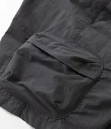 Bermuda cargo negra de tejido tecnológico (poliamida), con corte holgado, bolsillos laterales funcionales y cintura elástica con cordón ajustable.