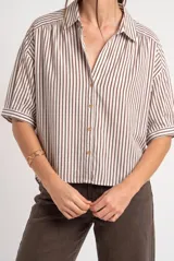 Camisa oversize a rayas marrones y blancas, con mangas cortas y cierre frontal de botones.