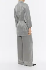 Chaqueta gris de lyocell con corte recto, escote con solapas, manga larga recta y cierre frontal con cinturón de tejido. Tiene bolsillos plastrón redondeados en el delantero.