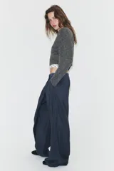 Pantalón de tiro alto con diseño cruzado tipo pareo en el frente, pernera ancha y caída fluida.