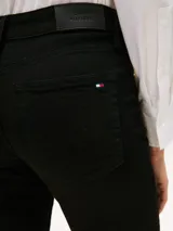Jeans denim de corte slim en color negro, diseño clásico de cinco bolsillos y trabillas para cinturón.