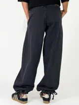 Pantalon de denim azul de corte holgado, con cintura elástica y puños ajustables con cordones en los tobillos.